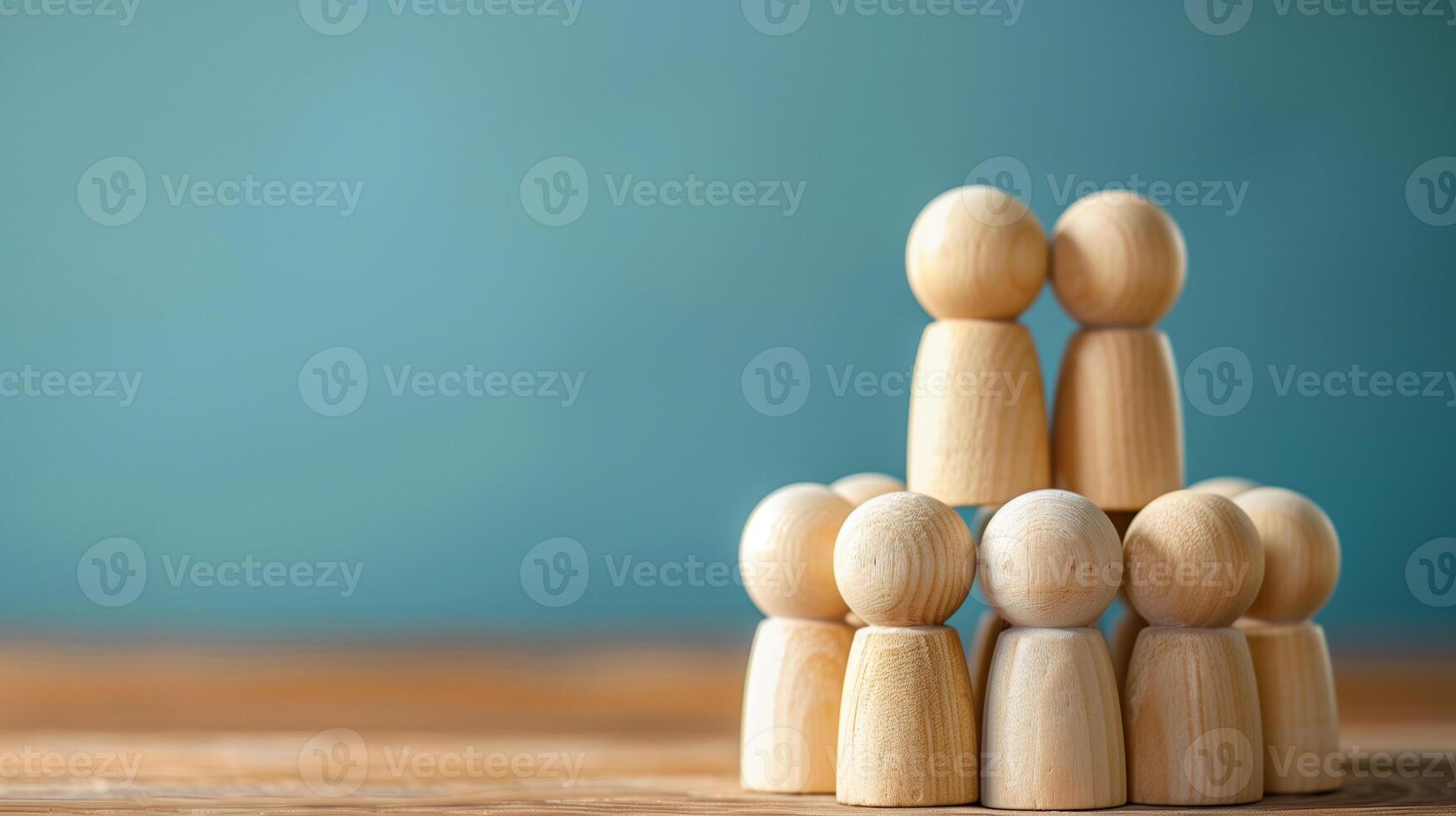 Wooden figures assembled in tiers. Wooden figurines stacked in two tiers against a blue backdrop. . photo
