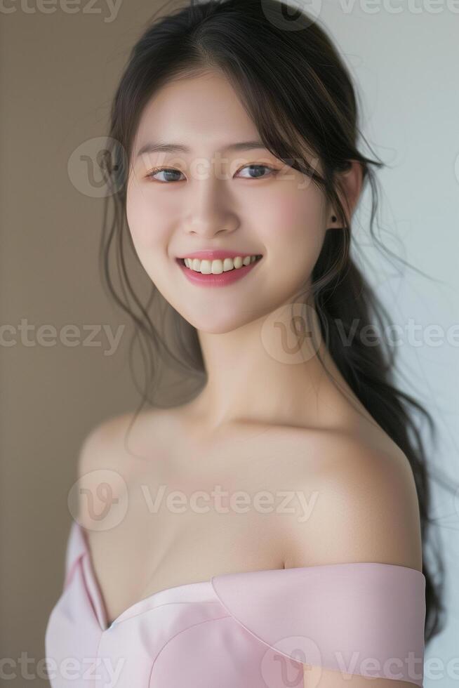 Radiant smile of a young Asian woman in a pink dress. Portrait of a joyful Asian woman with long dark hair, wearing an elegant pink off-shoulder dress, smiling brightly. . photo