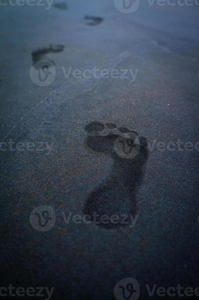 soles of feet, footprints on the beach sand photo