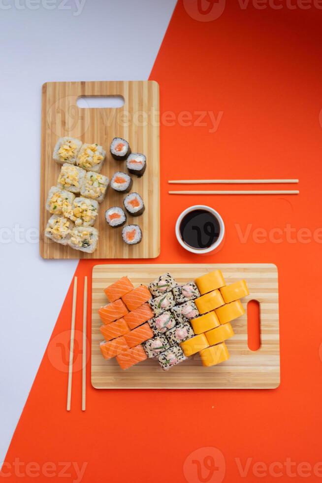 Sushi delivery. Set of rolls in a disposable box on a black background. Top view photo