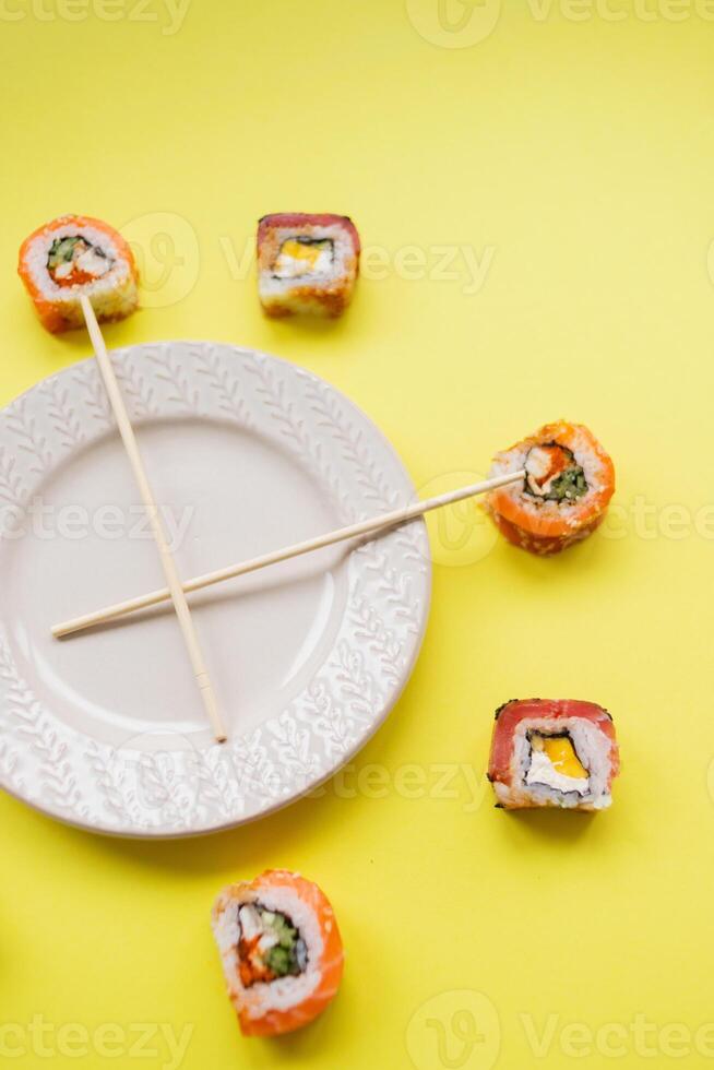 Sushi delivery. Set of rolls in a disposable box on a black background. Top view photo