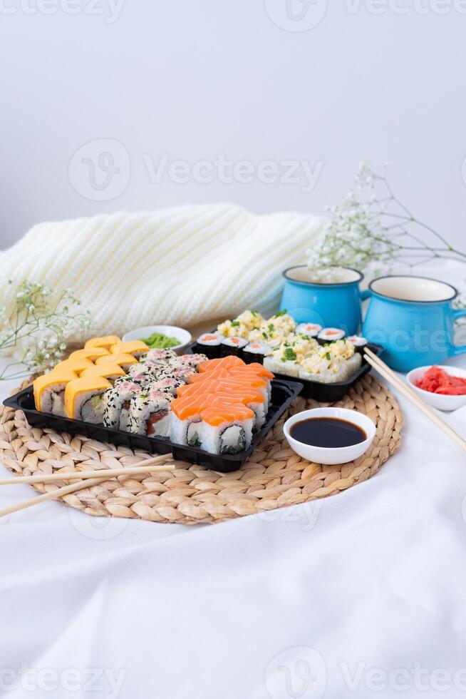 Sushi delivery. Set of rolls in a disposable box on a black background. Top view photo