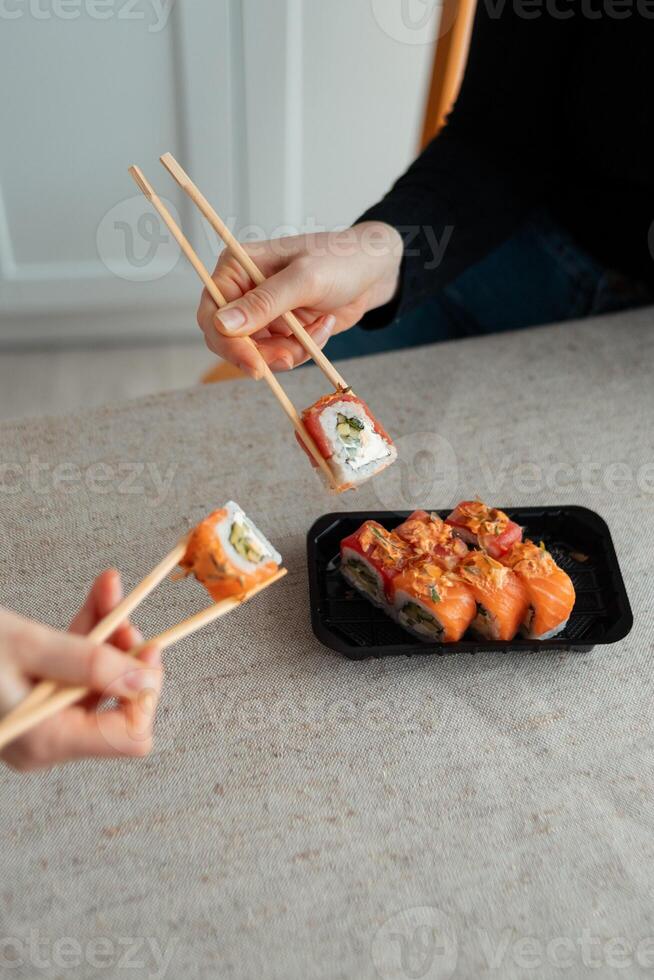 Sushi delivery. Set of rolls in a disposable box on a black background. Top view photo