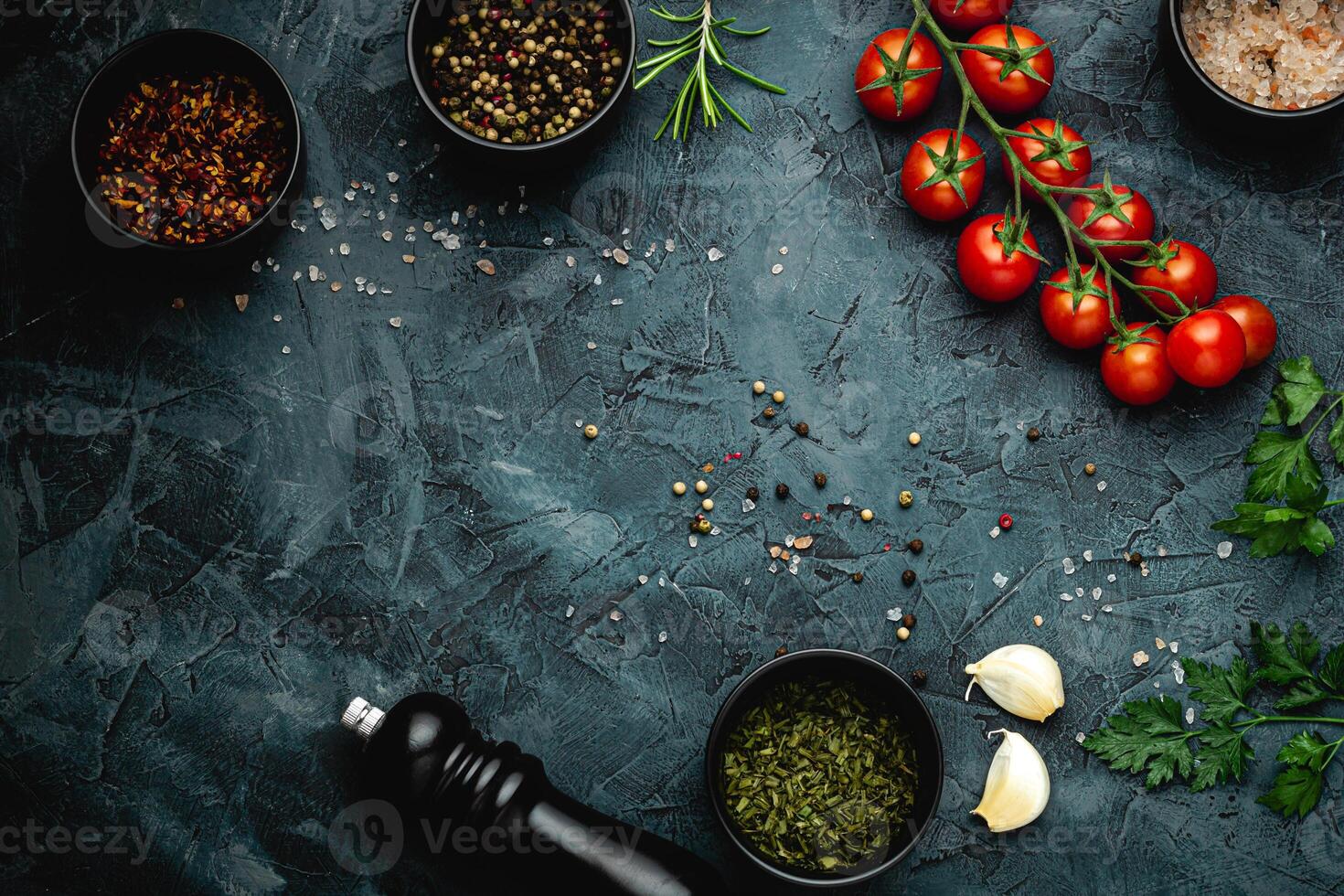 Dark stone kitchen background with spices, herbs and kitchen utensils. Free space for text. Top view. Rustic style. photo