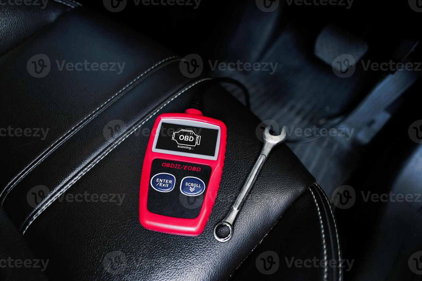 OBD2 or OBD scanner and wrench on car leather seat for engine system analysis to fixing car engine system , Car maintenance service concept photo