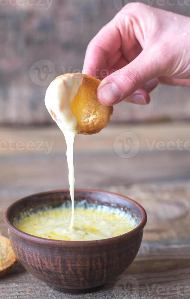 Bowl of cheese dip with toasts photo