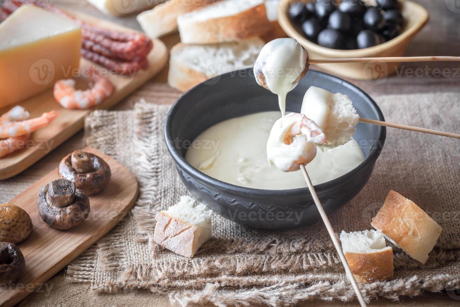 Bowl of fondue with appetizers photo
