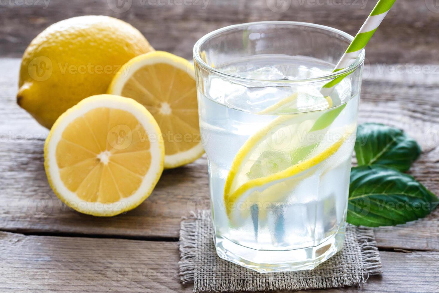 Glass of water with fresh lemon juice photo