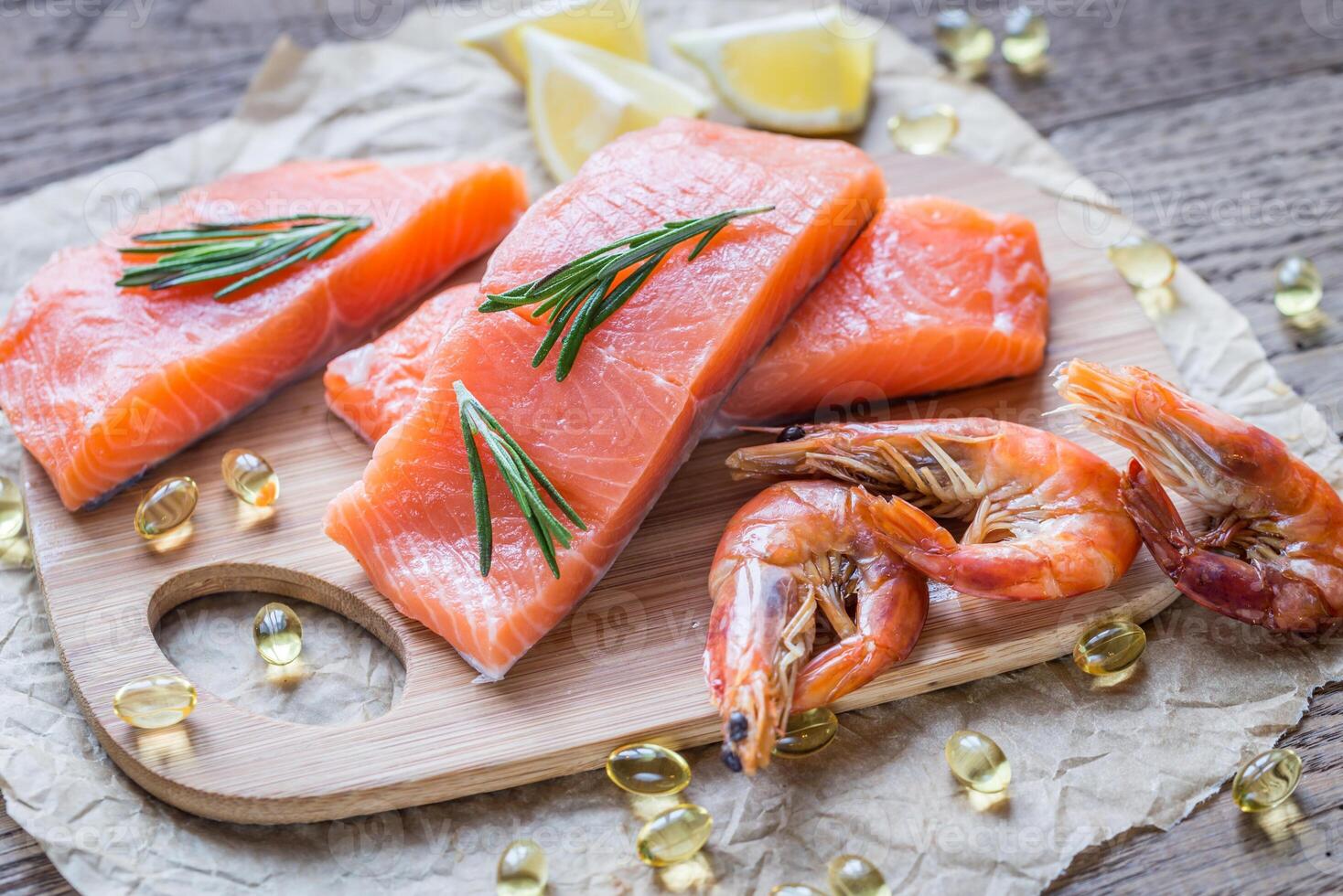 Raw salmon with shrimps on the wooden board photo