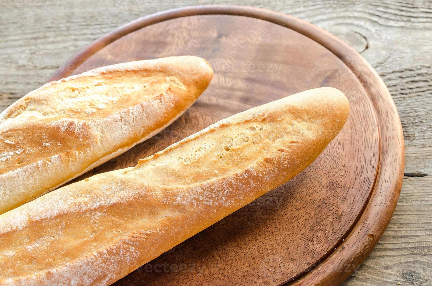 Two baguettes on the wooden tray photo