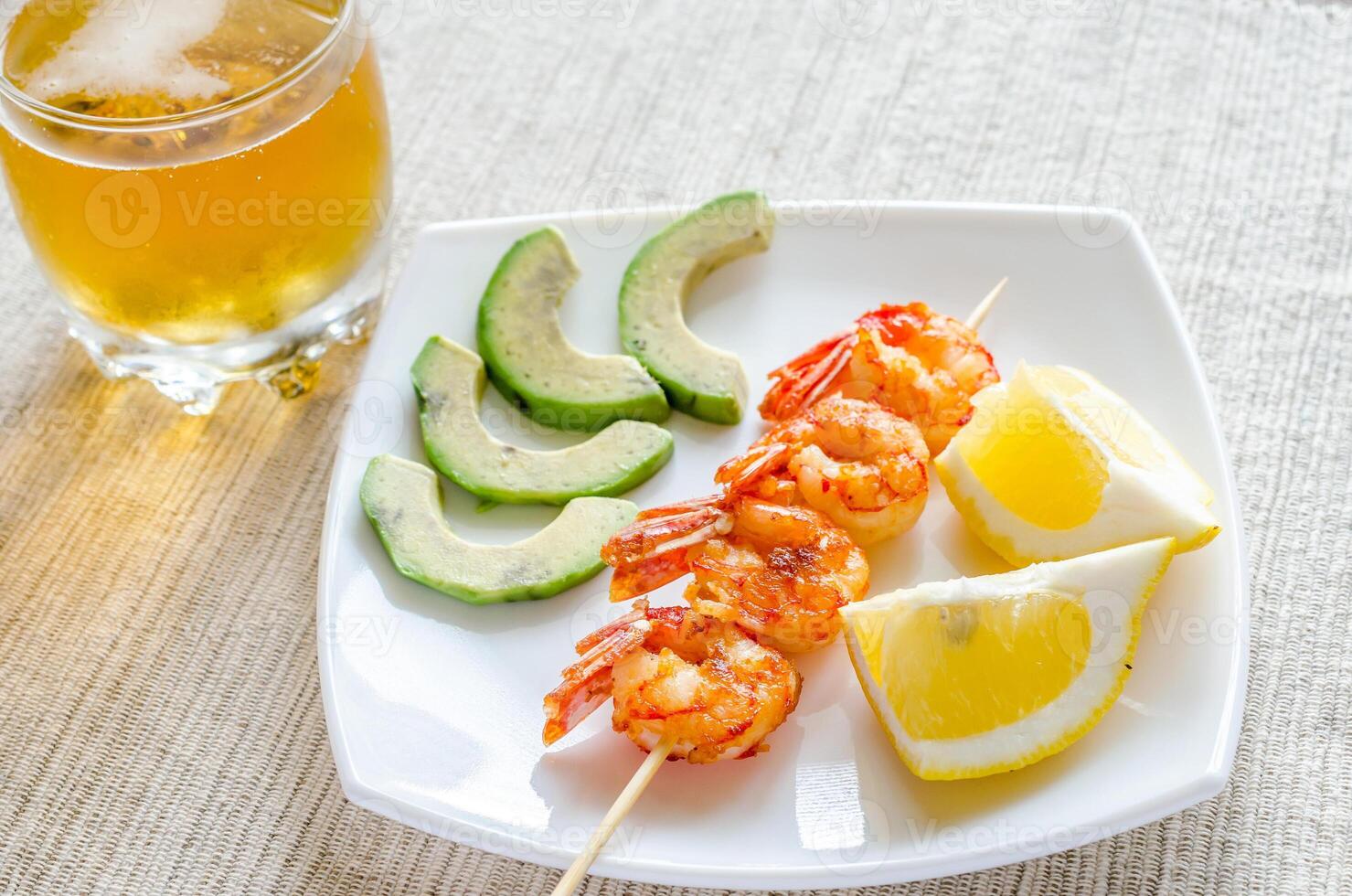 Shrimps skewers with avocado and lemon slices photo
