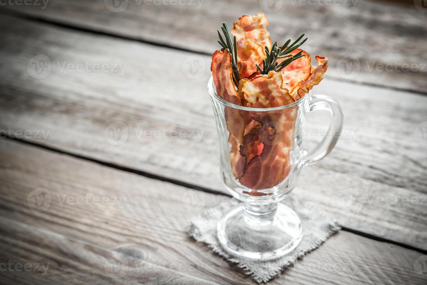 Fried bacon strips with fresh rosemary photo