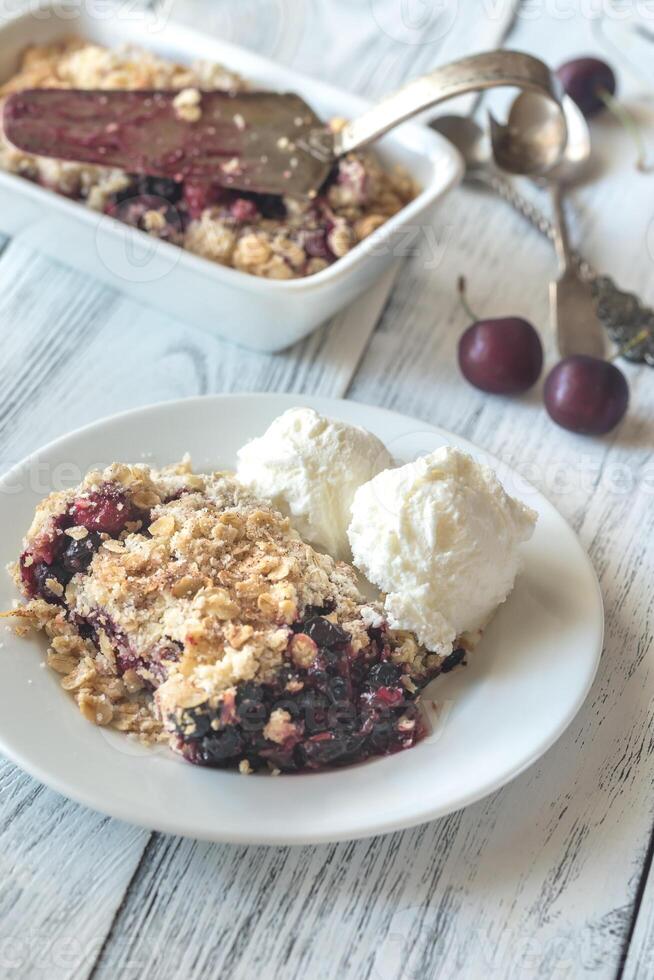 Portion of berry crumble with vanilla ice cream photo