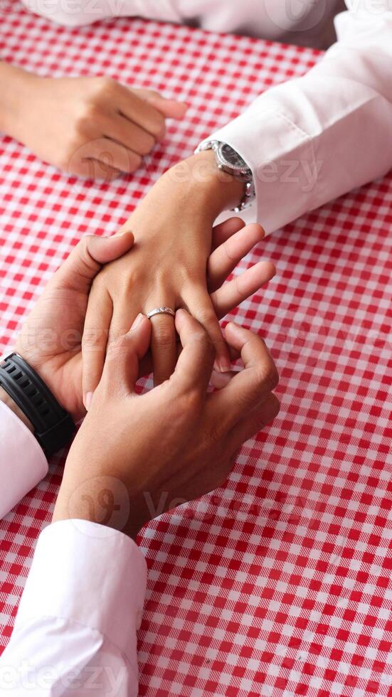 Happy moments when a man proposes to his girlfriend by giving a ring at a cafe. photo