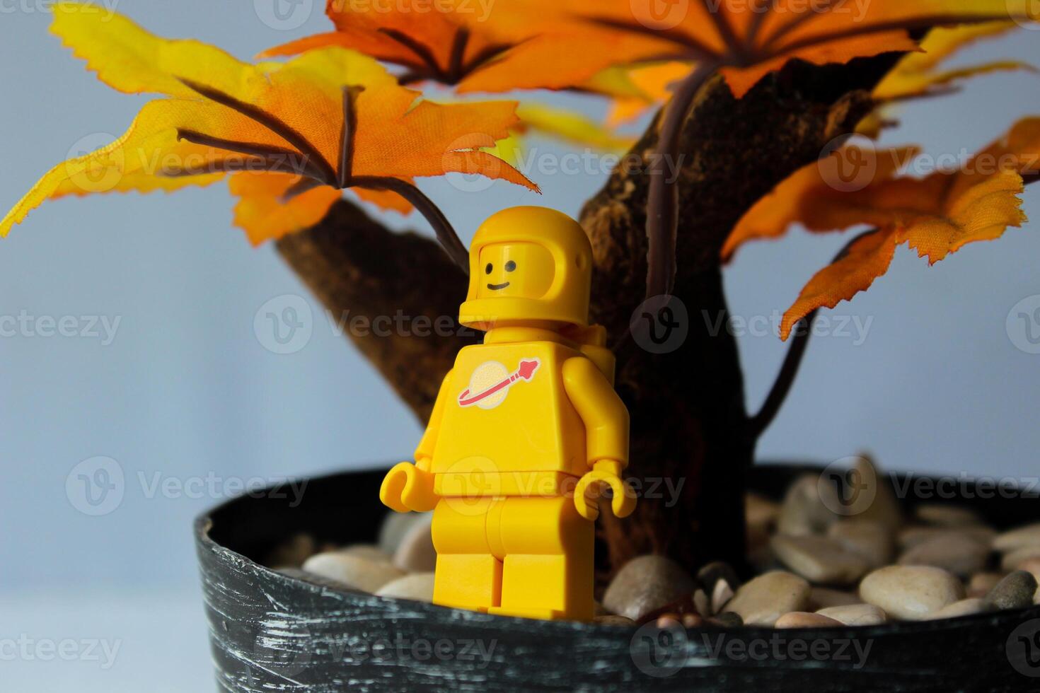 The yellow astronaut lego character is enjoying autumn with a smiling expression. photo