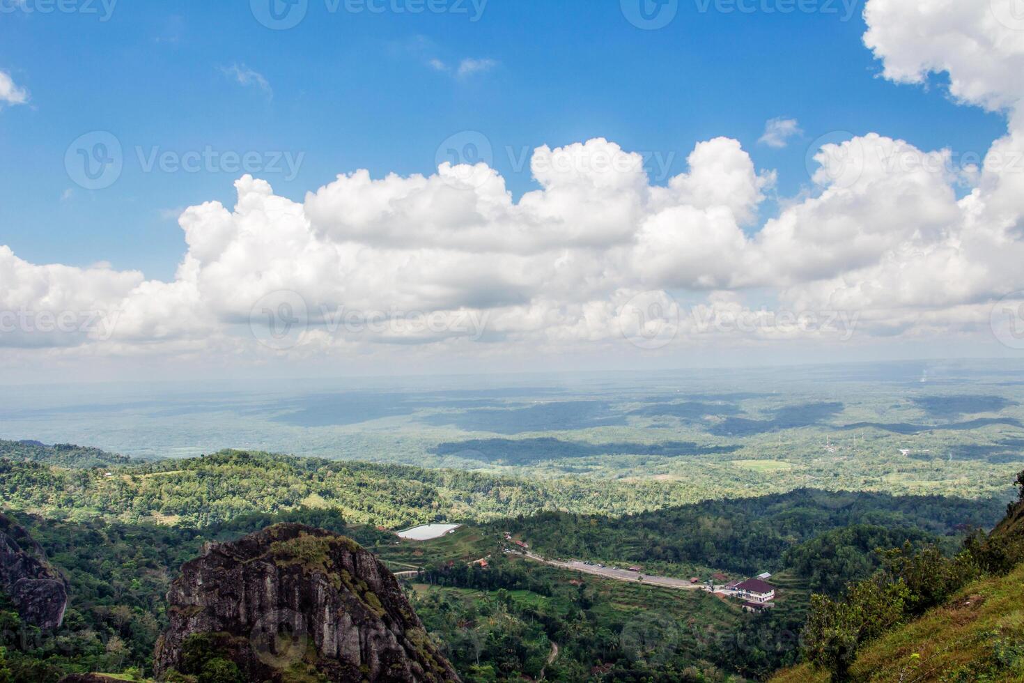 The view from the top of the hill with a stretch of blue sky and a bunch of white clouds. photo