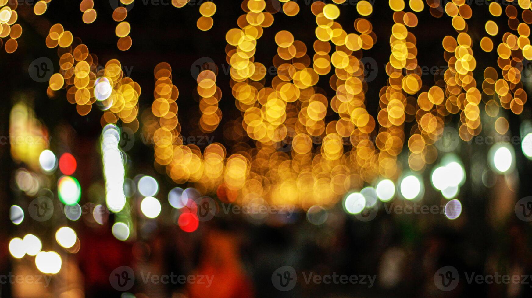 the glittering background of multicolored glowing lights is blurred photo