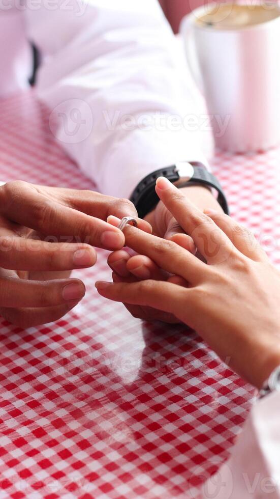 Happy moments when a man proposes to his girlfriend by giving a ring at a cafe. photo