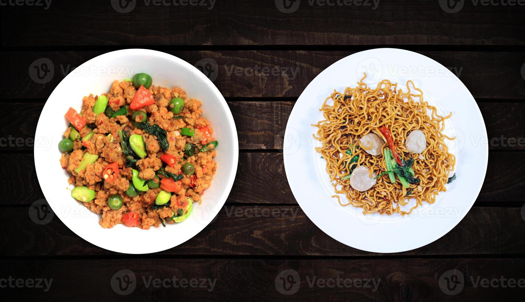 Side dishes, soy vegetables and peas and spicy meat fried noodles on a white plate on a dark wooden background. Top view. photo
