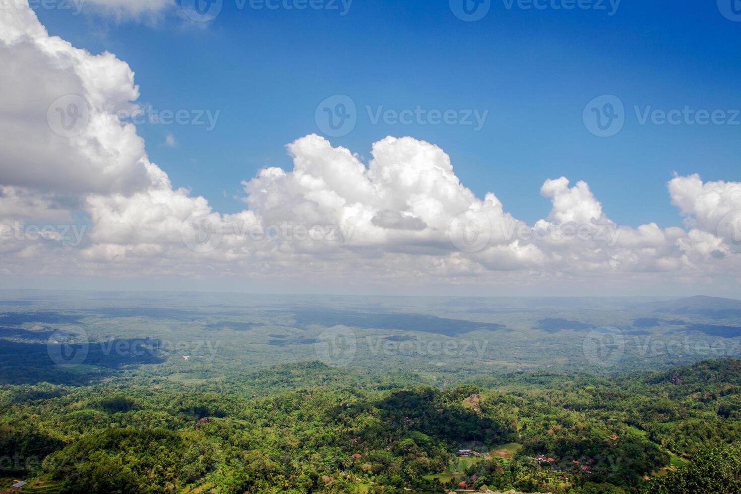 The view from the top of the hill with a stretch of blue sky and a bunch of white clouds. photo