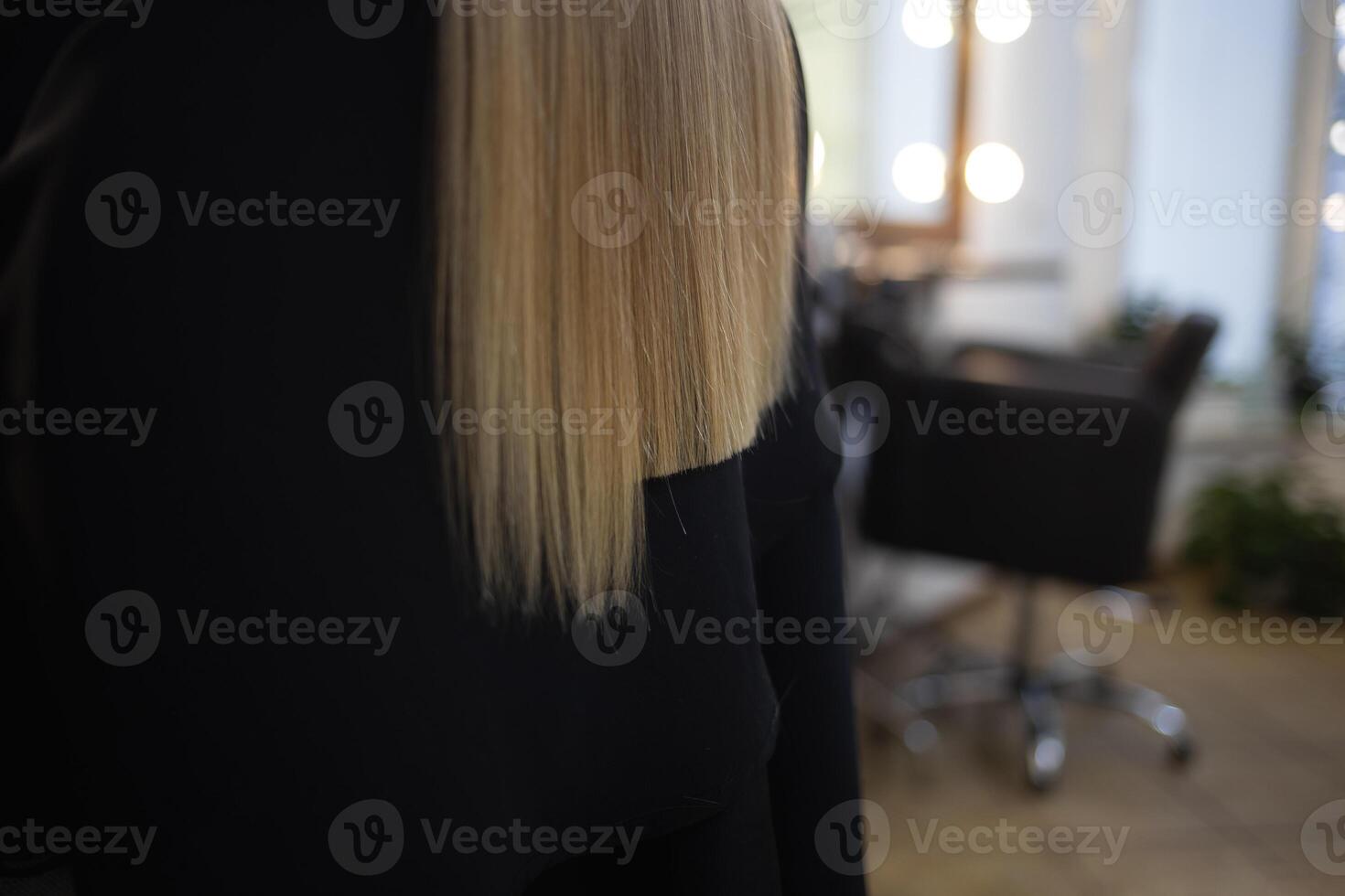 the hairdresser in the barbershop cuts the hair of a little cute girl photo
