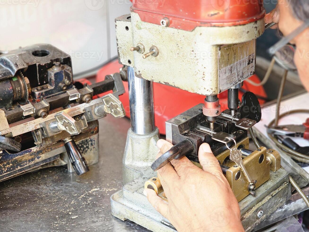 skilled locksmith is copying keys with his machine with copy space photo