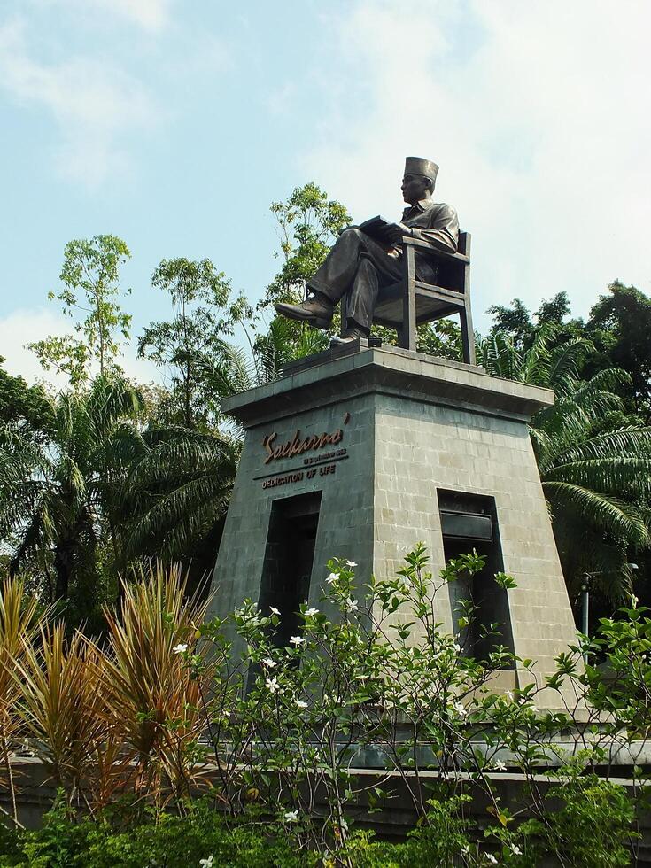 Surakarta, Central Java, Indonesia April 11, 2024. The statue of Mr Soekarno sitting while reading a book, statue of the first president of The Republik Indonesia at Manahan Stadium. photo