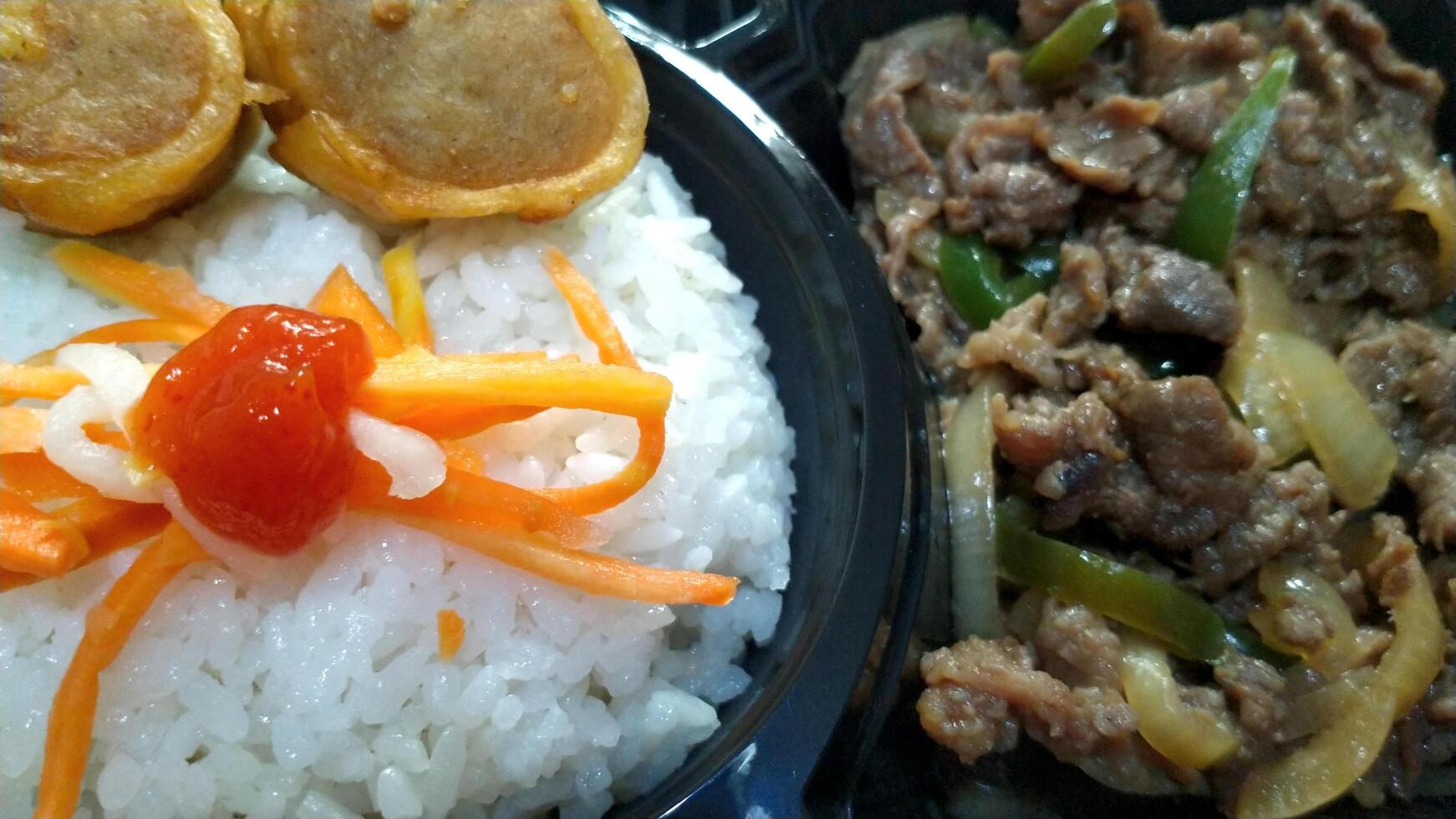 Japanese Rice dish containing rice, beef teriyaki, salad and dressing, and fried snacks photo