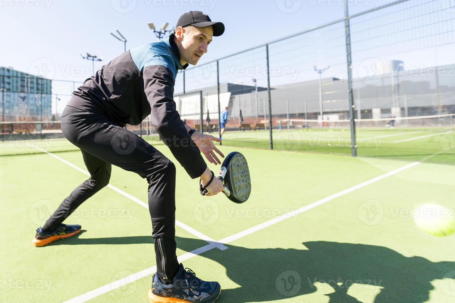 paddle tennis coach teaching on a residential paddle court, front view photo