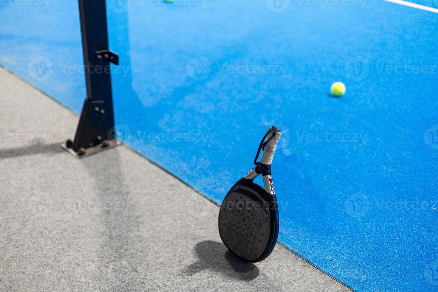 Closeup view of a paddle racket in a padel tennis court near the net. Sport, health, youth and leisure concept. Sporty equipment. White lines in background photo
