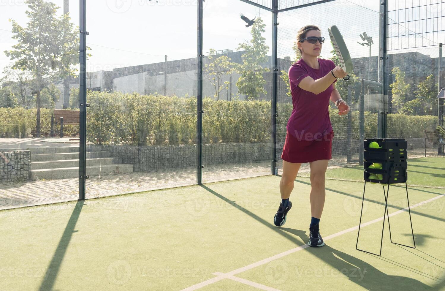 Close up of athletic woman with paddle tennis racket and ball on outdoor court. photo