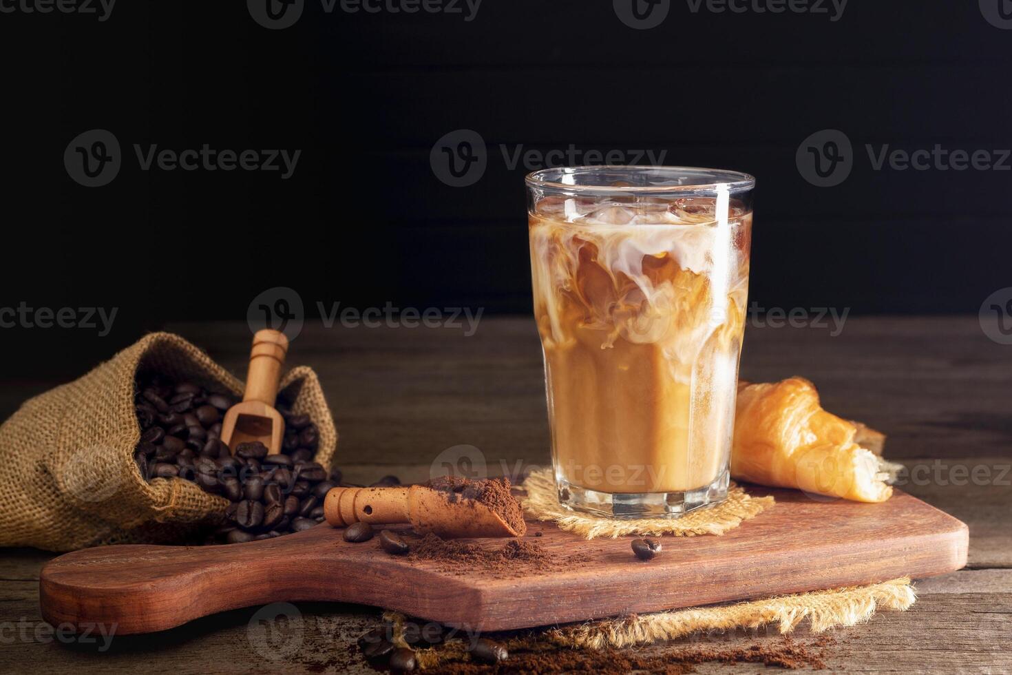 Soft iced coffee with milk, cream, white foam and ice. Coffee latte, espresso, cappuccino, cocktail ready to drink on dark and black background. photo
