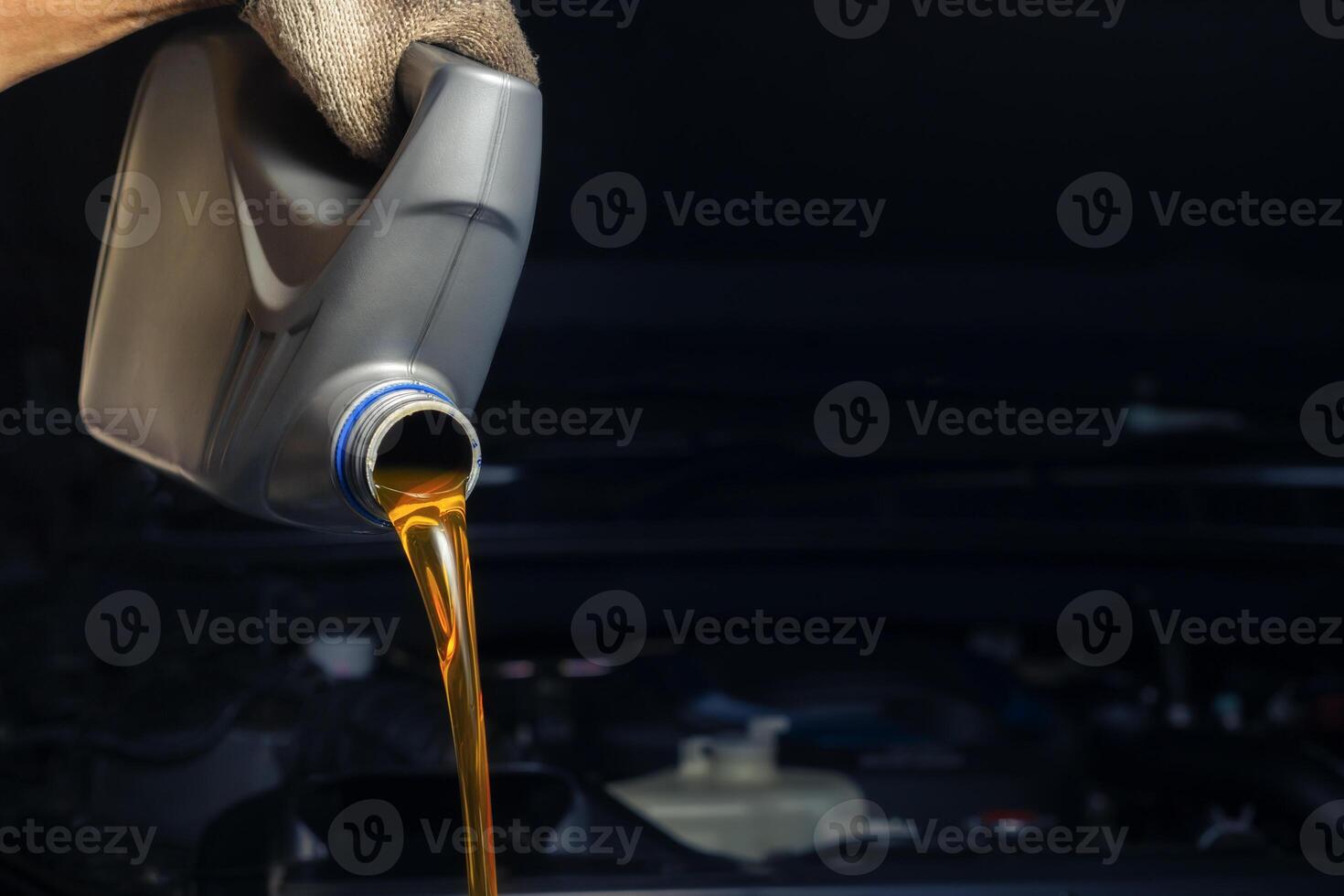 Pour engine oil from the lubricant bottle. Engine background, oil change shop engine service industry photo