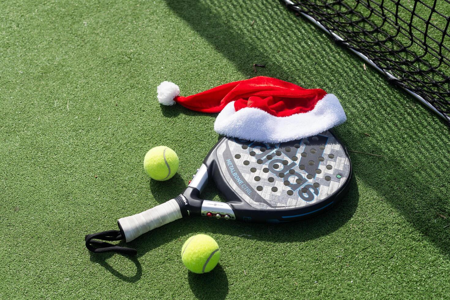 Ukraine Kyiv, April 02 2024. Christmas Open Padel Tournament. Poster for social networks for New Year's games. Padel tennis racket on tournament. paddle racket on court photo