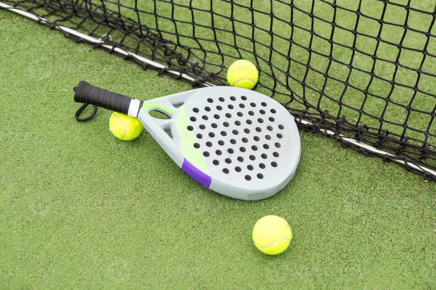 Paddle racket, next to the ball and on a carpet of the play area photo
