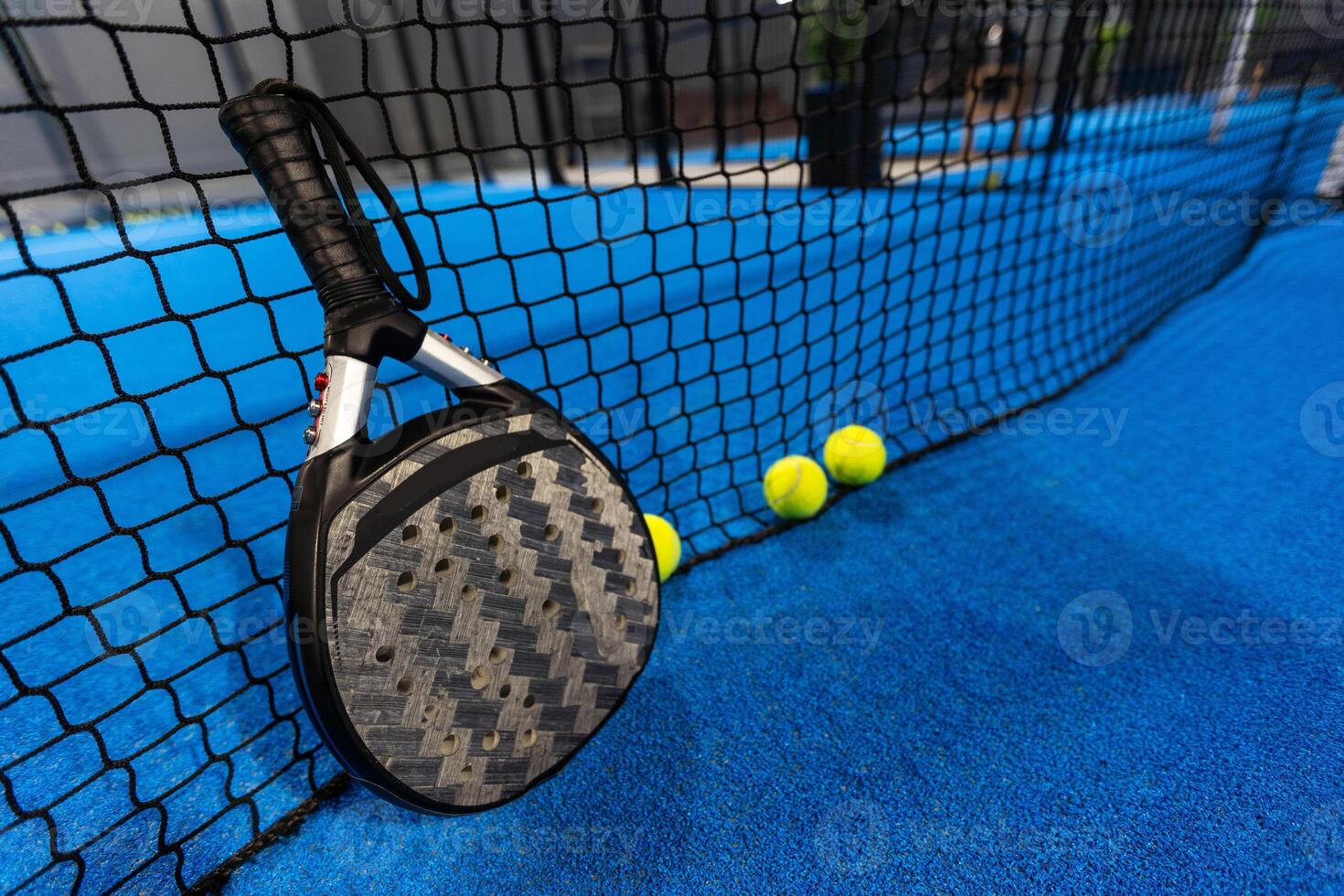 paddle tennis racket and balls on the blue paddle court photo