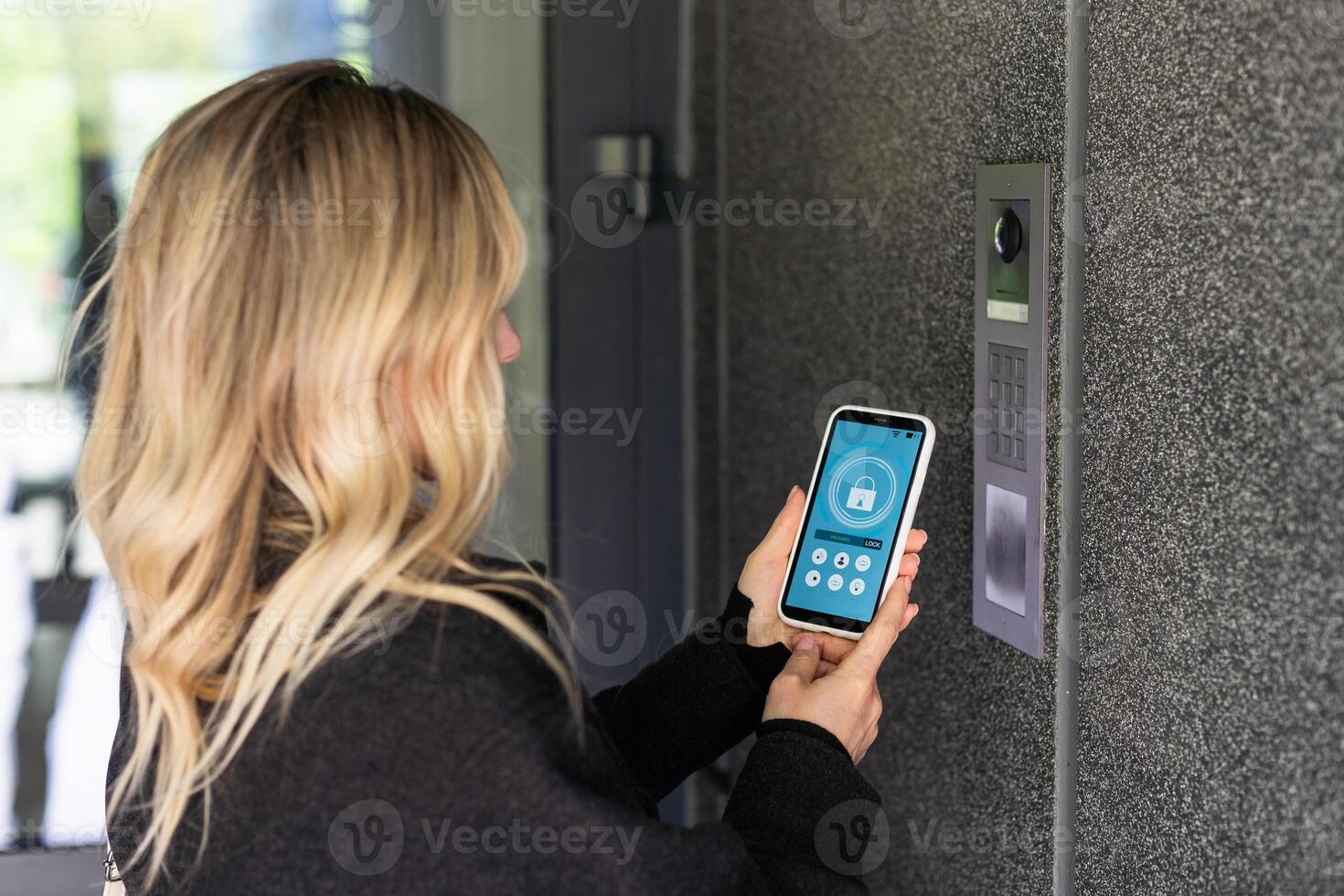 Smiling woman setting home security system with help of mobile application. photo