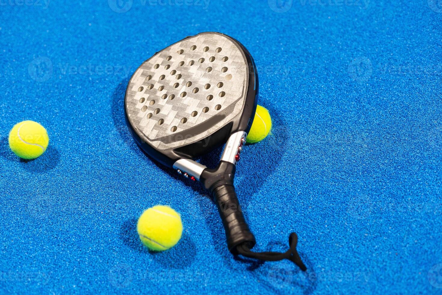 paddle tennis racket and balls on the blue paddle court photo