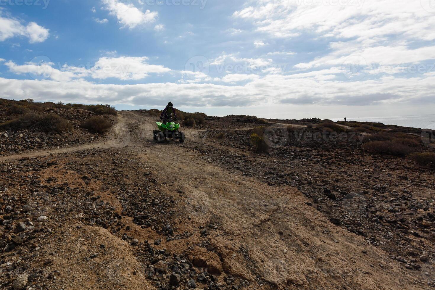 A man riding ATV in sand in protective helmet photo