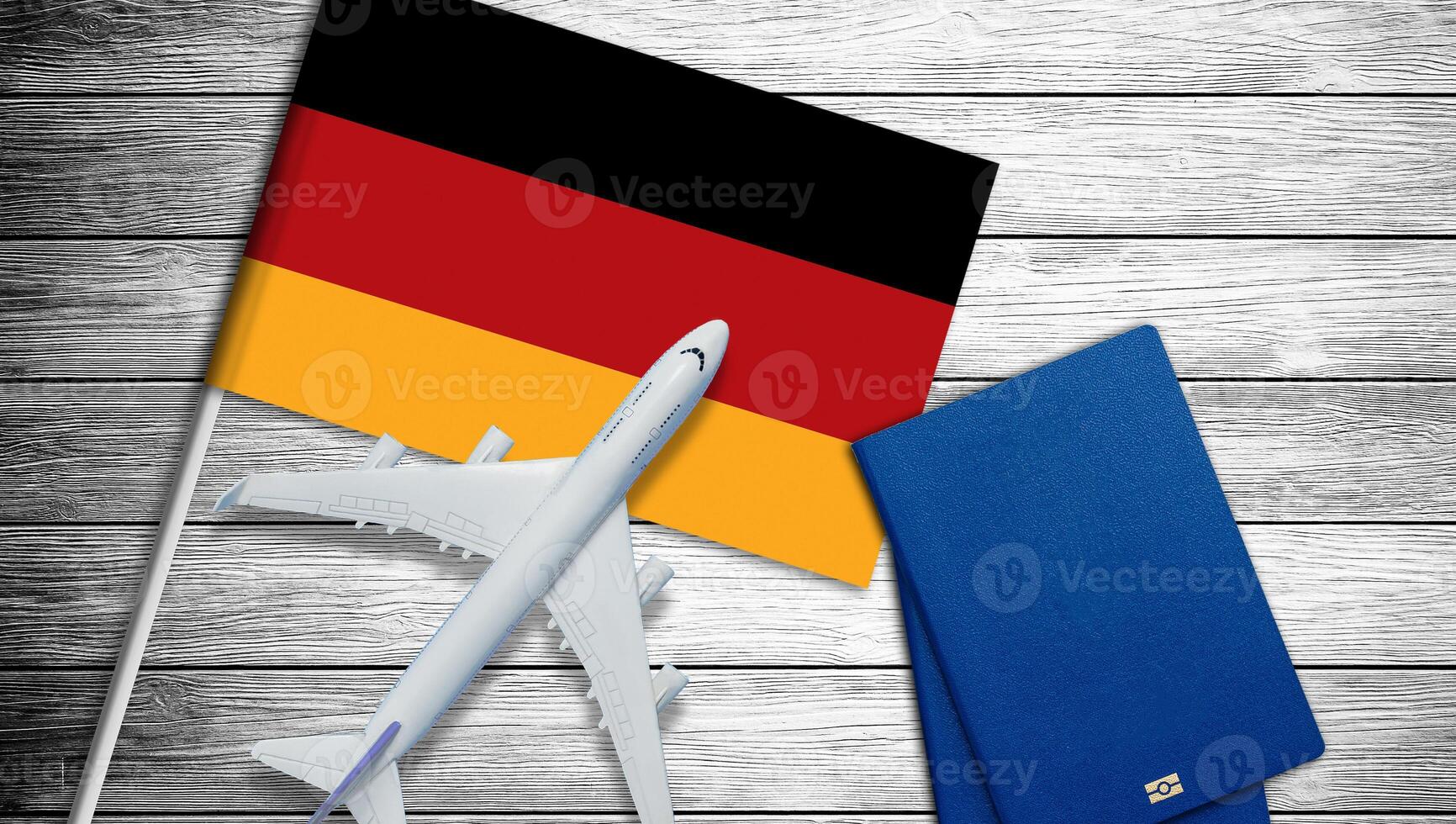 Flag of Germany with passport and toy airplane. Flight travel concept. photo
