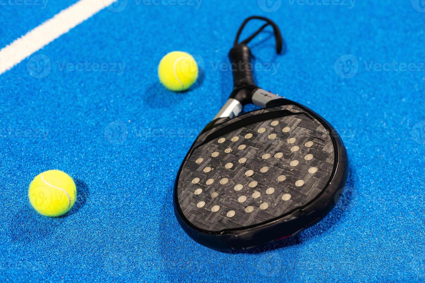 paddle tennis racket and balls on the blue paddle court photo