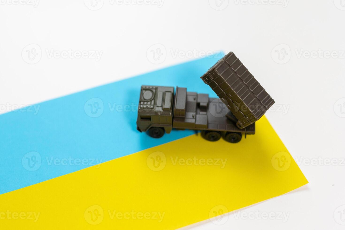 Artillery rocket system are aimed to the sky and soldier at sunset with Ukrainian flag. Multiple launch rocket system. photo
