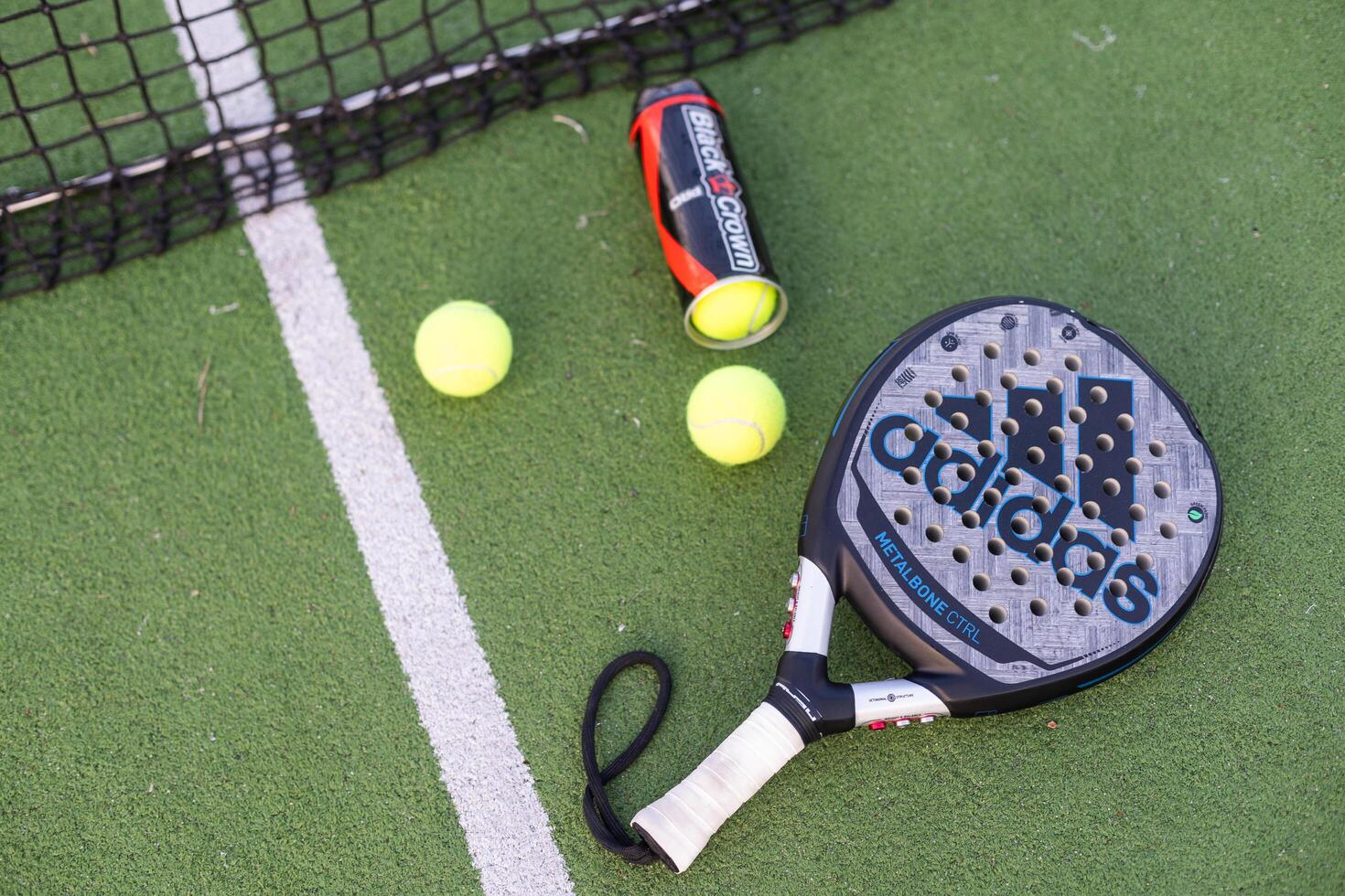 Ukraine Kyiv, 30.03.2024. Padel racket adidas and padel ball on a green court photo