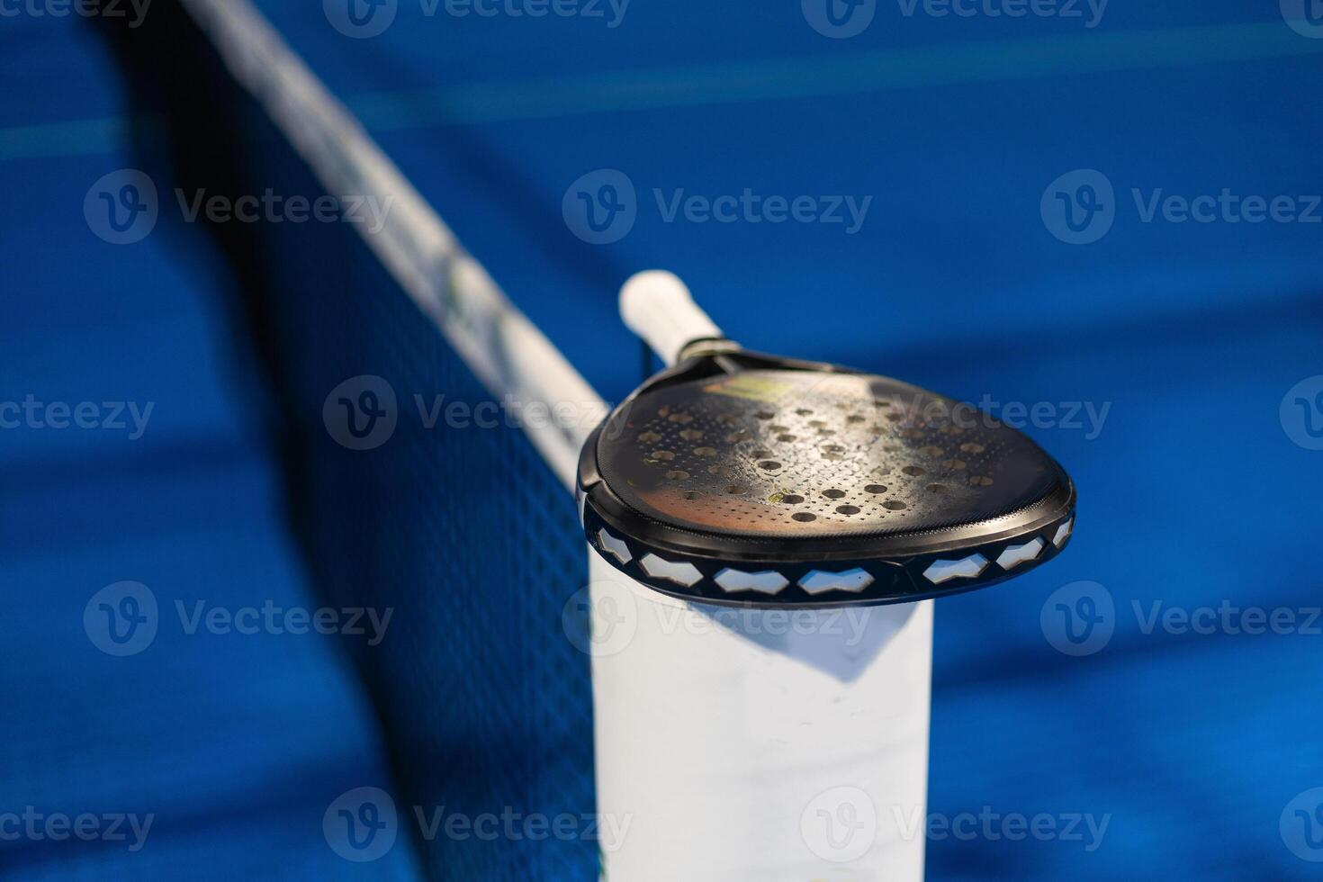 Paddle tennis. Paddel racket and ball in front of an outdoor court photo