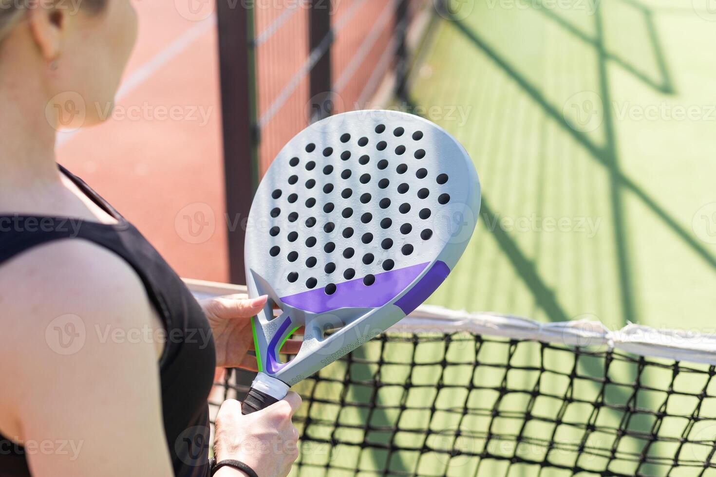 hands of a woman paddle player is holding balls and the racket at the background at the beginning of the match outdoors photo