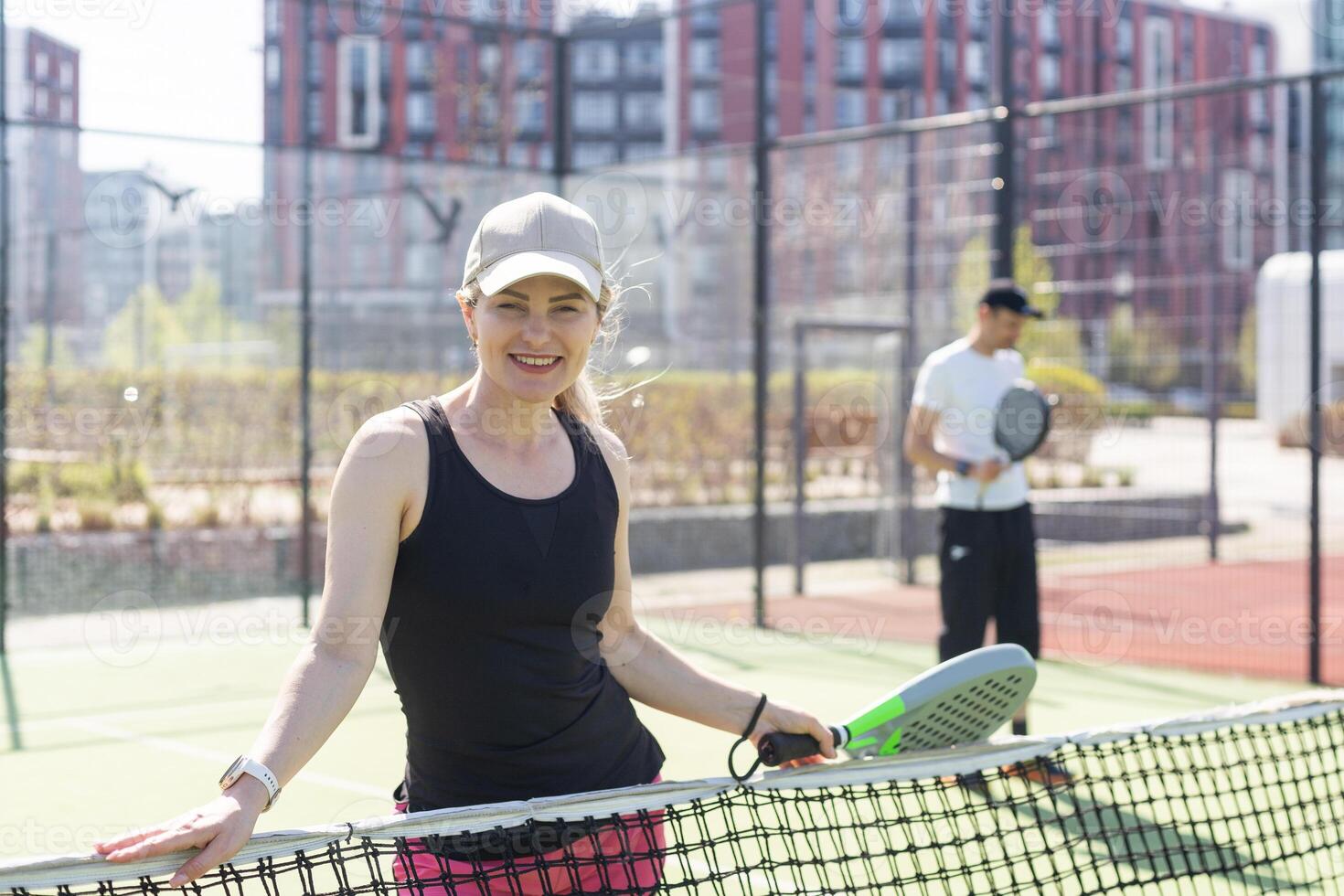 hands of a woman paddle player is holding balls and the racket at the background at the beginning of the match outdoors photo