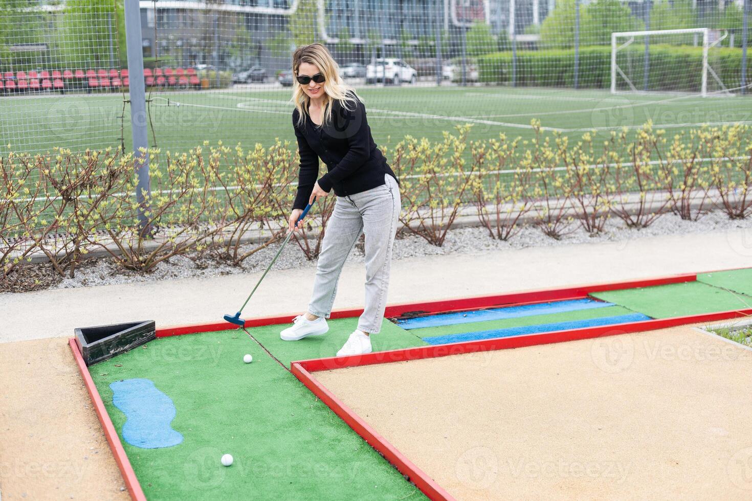 Playing Adventure Golf, downhill shot, ball, club and hole. photo