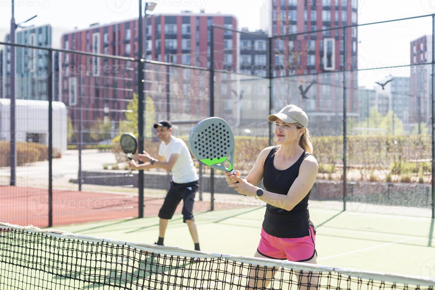 hands of a woman paddle player is holding balls and the racket at the background at the beginning of the match outdoors photo