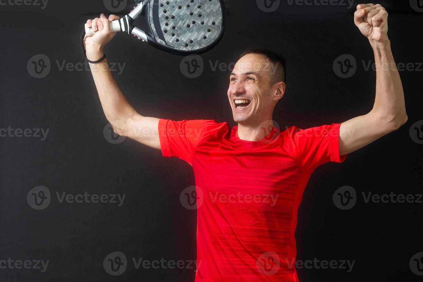 Smiling man with racket and paddle ball dressed in sport clothes isolated background. Front view. photo
