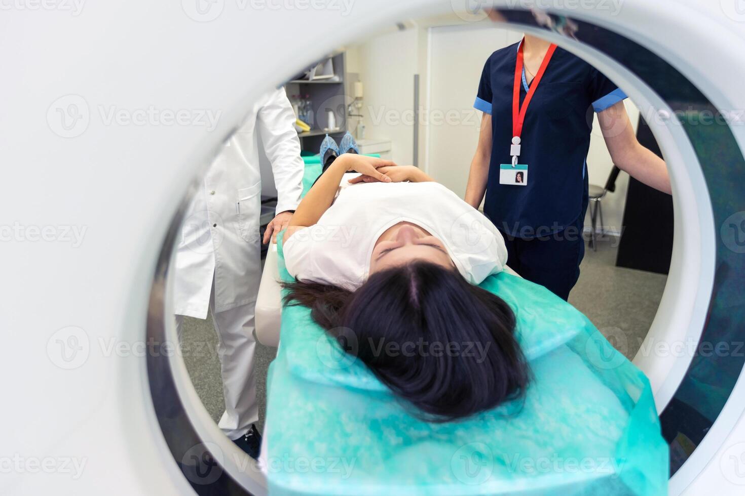 Radiologist with a female patient in the room of computed tomography. photo